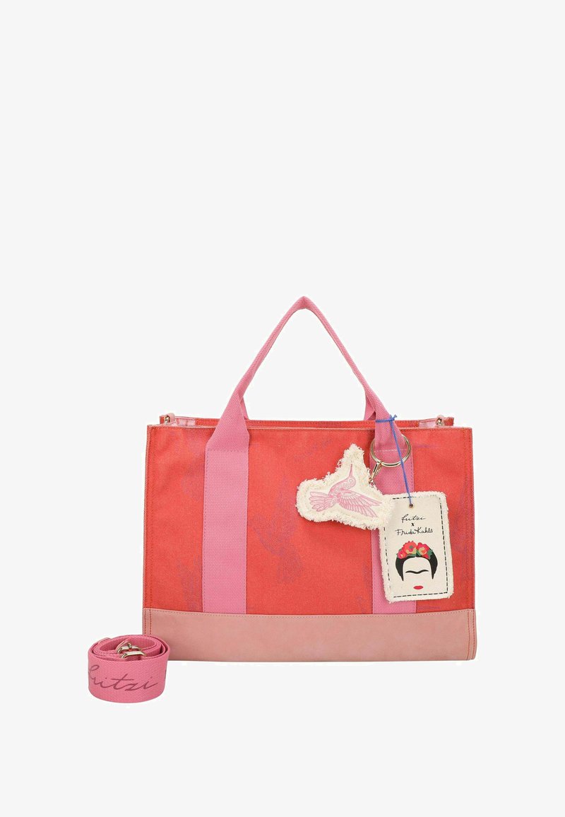 Sac fourre-tout en toile corail et rose avec des poignées en tissu robustes, une base en cuir rose, un charm décoratif et une étiquette ornée d'une illustration de Frida Kahlo.