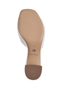 Hvid damesko-sål med en beige gummibase, struktureret for greb. Har et lille rundt metalaccent og præget branding.