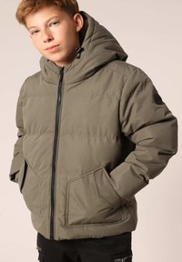 Doudoune vert olive avec capuche, fermeture éclair, poches avant et tissu texturé. Présente un badge sur la manche gauche.