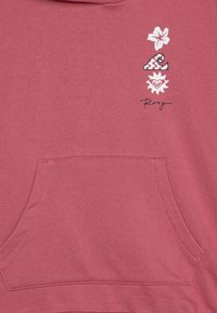 Hoodie rose avec une poche avant. Décoré d'un graphique floral, de vagues et de soleil en blanc avec des motifs.