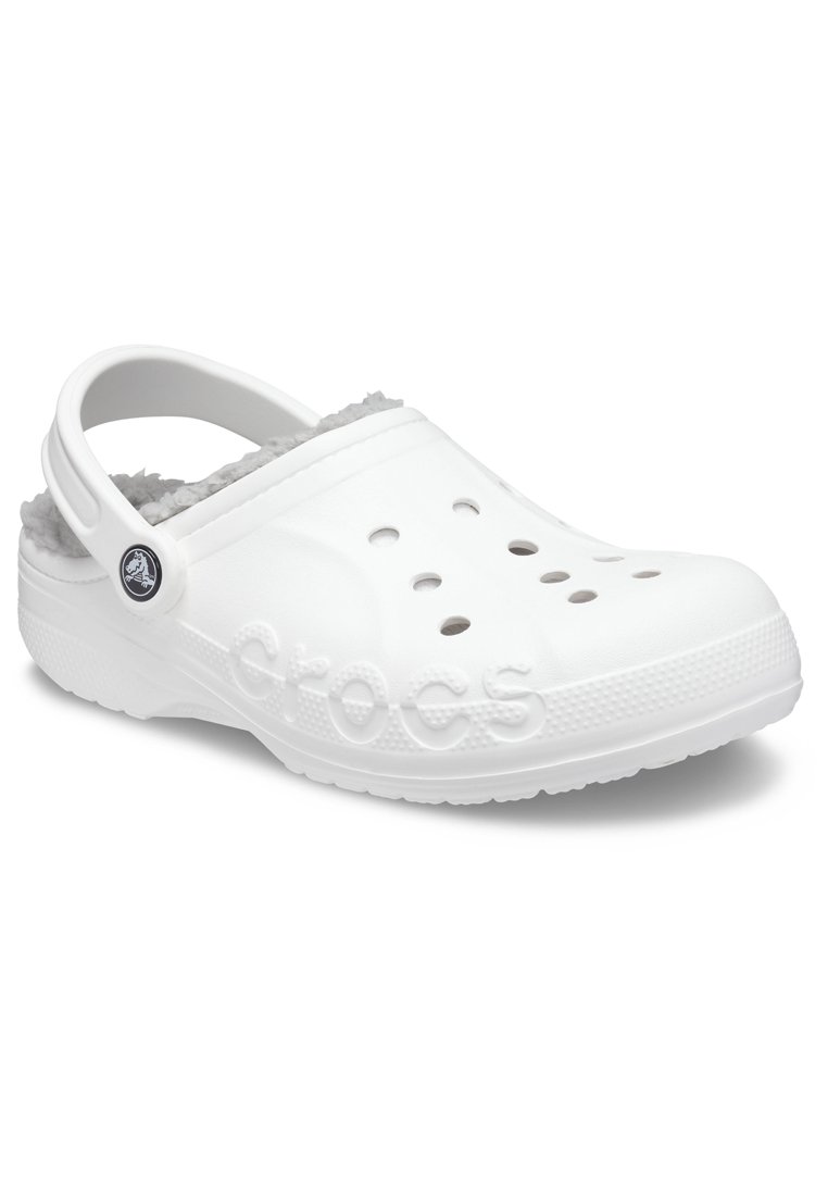 Witte Crocs klompen met een zachte grijze fuzzy binnenkant, voorzien van ventilatiegaten, een verstelbare hielband en een gestructureerde witte zool.