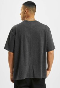 T-shirt grigio a maniche corte realizzato in morbido misto cotone, con taglio dritto e dettaglio di cucitura sul retro.