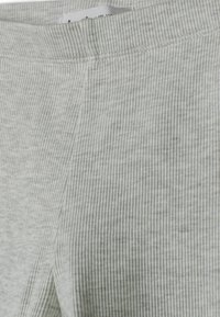 Nahaufnahme eines grauen gerippten Strickstoffs, der die Nahtdetails und den Bund zeigt und die Textur und die Nähte hervorhebt.