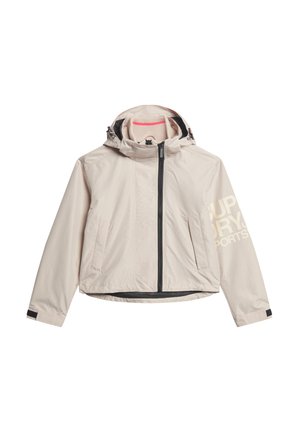 Lys beige udendørsjakke med tætsiddende design, sort lynlås, sidelommer og hætte. Har et stort "SUPERDRY" logo på ærmet.