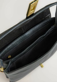 Borsa in pelle nera con una finitura testurizzata, dotata di una chiusura in metallo dorato, molteplici scomparti e una morbida fodera interna.