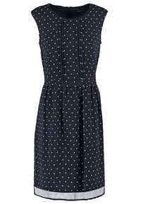 Robe sans manches bleu marine à pois blancs, encolure arrondie, taille ajustée et plis subtils sur le buste avant.