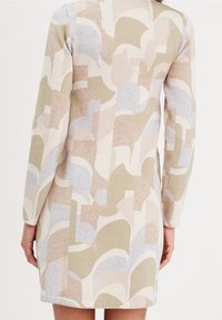 Strikkjole med et abstrakt mønster i beige, blå og olivengrøn. Lange ærmer, lige snit og tekstureret stof, knælængde.