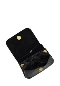 Petite pochette en cuir noir avec intérieur texturé, boutons-pression dorés et rabat ouvert montrant un compartiment vide.