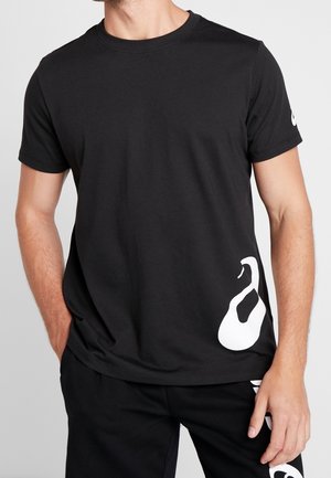 T-shirt en coton noir à manches courtes, avec un grand design abstrait blanc sur le bas et un logo blanc sur la manche.