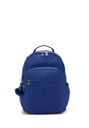 Sac à dos bleu avec poche avant zippée, poignée supérieure, poches latérales et un petit porte-clés peluche fixé à la tirette du zip côté gauche.
