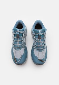 Scarpe da trail running azzurro chiaro con tomaia in mesh, dettagli riflettenti, sistema di allacciatura rapida e suole in gomma texturizzata per una migliore presa.