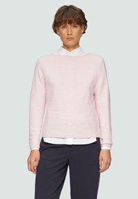 Helles rosa geripptes Sweatshirt mit langen Ärmeln, rundem Halsausschnitt und lockerer Passform, über einem weißen Hemd mit Kragen und einer Marineblauen Hose getragen.