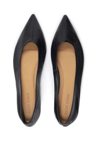 Bailarinas de cuero negro con punta afilada, que cuentan con una textura suave y una plantilla marrón marcada "KAZAR STUDIO." Diseño sencillo para poner y quitar fácilmente.