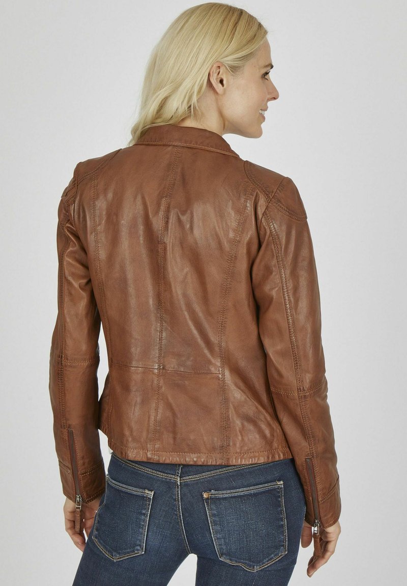 Braune Lederjacke mit tailliertem Design, sichtbaren Nähten und Reißverschlüssen an den Ärmeln. Strukturierte Oberfläche, Rundhalsausschnitt und mittellange Ausführung.