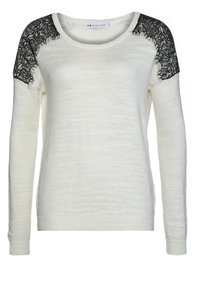 Pull blanc à manches longues avec détail en dentelle noire sur les épaules et poignets et ourlet côtelés.
