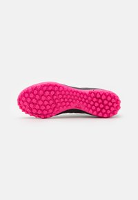 Sole di scarpa sportiva nera con un vivace motivo di trazione esagonale rosa. Battistrada progettato per una maggiore aderenza e stabilità sulle superfici.