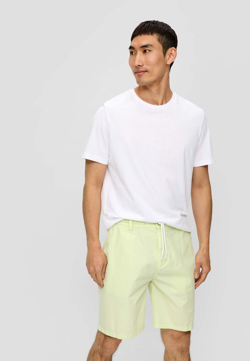 Witte katoenen t-shirt gecombineerd met lichtgroene katoenen shorts met een elastische tailleband en trekkoord. Gladde textuur, casual pasvorm.