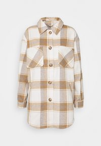 Kostkovaná košile na knoflíky v krémové a béžové barvě, vyrobená z měkké tkaniny. Obsahuje dvě kapsy na prsou a klasický límec, s viditelnými detaily šití.