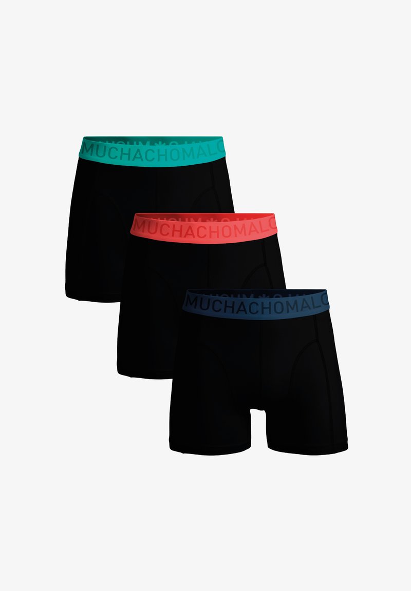 Tri páry čiernych boxerských trenírok s farebnými elastickými pásmi; horné má tyrkysovú farbu, stredné koralovú, spodné námornícku modrú, všetky s nápisom "MUCHACHOMALO".