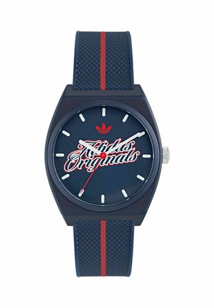 Temno modra ura Adidas Originals z rdečimi poudarki, belimi številčnicami in teksturiranim paščkom sredi rdeče črte.
