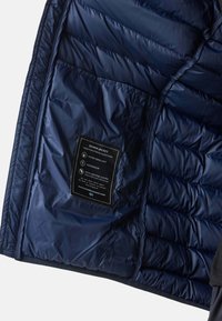 Innenraum einer marineblauen Daunenjacke mit horizontalem Steppmuster. Enthält ein Etikett mit Pflegehinweisen. Wasserabweisende und winddichte Eigenschaften.