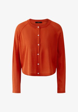 Cardigan court orange rouille avec manches longues raglan et six boutons sur le devant, présentant un col rond et un tissu en maille douce.