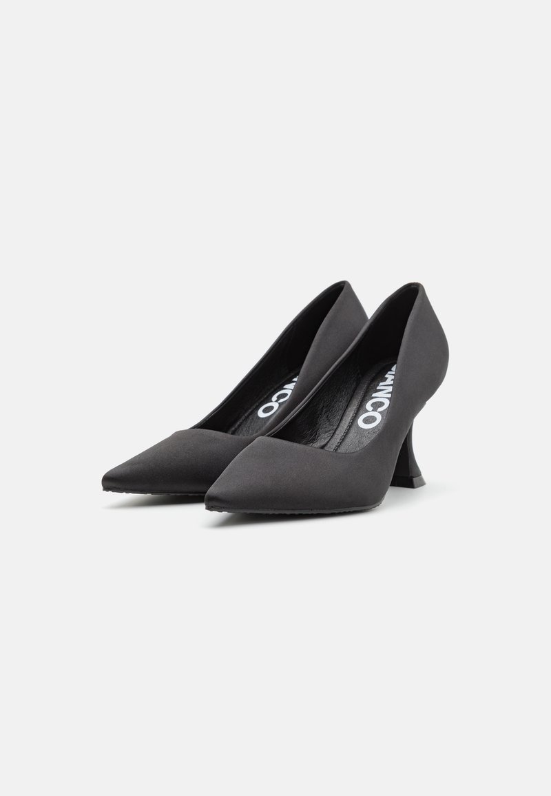 Schwarze spitze Pumps mit einer samtartigen Textur, die einen markanten, eckigen Absatz und ein glattes, minimalistisches Design aufweisen.
