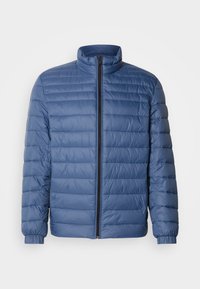 Modrá prošívaná bunda s vysokým límcem a dlouhými rukávy, která má plný přední zip a elastické manžety. Hladký, lehký materiál.