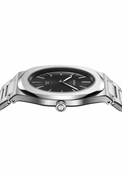 Montre-bracelet fine en métal argenté avec cadran rond noir, index et aiguilles argentés, indiquant 10h12, bracelet en acier inoxydable à maillons.