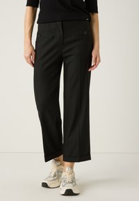 Schwarze, weit geschnittene Hose aus einem glatten Stoff; verfügt über vordere Taschen mit Knopfdetails und einer maßgeschneiderten Optik.