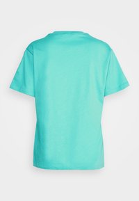 Camiseta de manga corta turquesa vista desde atrás con cuello redondo sobre un fondo blanco.