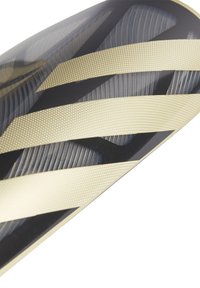 Paracalore nero e oro con strisce diagonali, superficie testurizzata e motivo a pois, progettato per proteggere dagli impatti e garantire comfort.