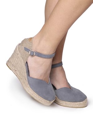 Grey suede wedge espadrilles with a woven jute midsole and ankle strap. Features a rounded toe and smooth texture.