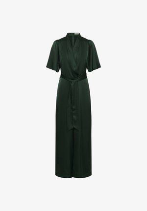 Tumši zaļš apmetņa kleita, izgatavota no gludas auduma. Ar īsām piedurknēm, siksniņu jostas vietā un platām kājām, kas nodrošina plūstošu stilu.