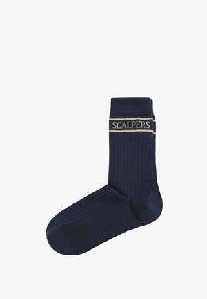 Chaussettes côtelées navy avec une bande beige clair arborant le texte "SCALPERS". Texture lisse et forme de chaussette traditionnelle.