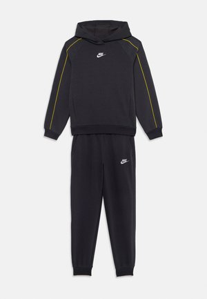 Nike tracksuit featuring a black hoodie with yellow accents and matching black pants, made from soft fabric, includes logo detailing.
