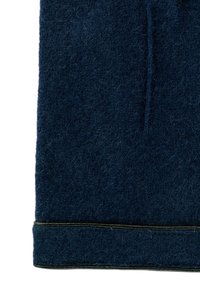 Close-up of dark blue wool fabric with visible texture and stitching along the bottom edge.