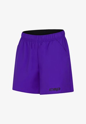 Purple athletic shorts with an elastic waistband, side pockets, and a black logo accent on the lower left. Lightweight fabric, smooth texture.