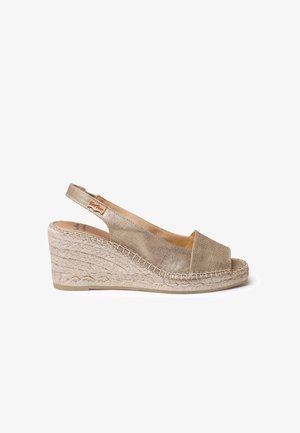 Zlaté tkaninové wedge sandále s otvorenou špičkou a dizajnom so slingbackom. Obsahuje pletenú jute podrážku a hladký metalický povrch.