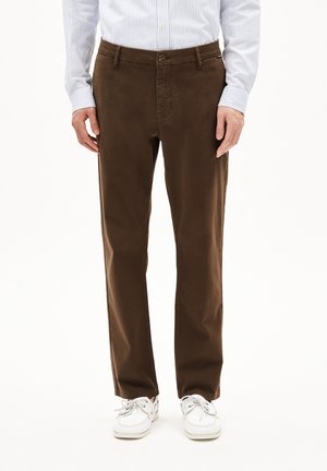 Bruine katoenen broek met een rechte pasvorm, riemlussen, voorzakken en een knoopsluiting, gecombineerd met witte schoenen.