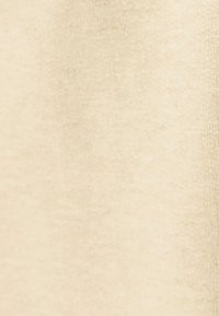 Tela beige con una textura suave, que presenta un tejido uniforme y consistente. Brillo sutil sin patrones o hardware visibles.