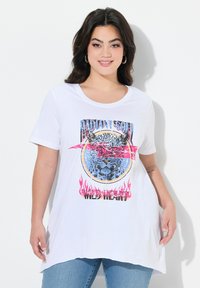 Camiseta blanca de manga corta que presenta un gráfico de la cara de un leopardo con acentos rosas, rodeado de texto y diseños de llamas en el dobladillo.