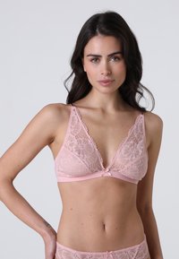Bralette in pizzo di un delicato rosa con motivo floreale, spalline regolabili e dettaglio in raso al centro. Fascia in satin liscio sotto il seno.