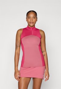 Conjunto de top atlético sem mangas e saia em tons de rosa. Apresenta um decote alto com meia zip e uma silhueta ajustada. O tecido aparenta ser suave.