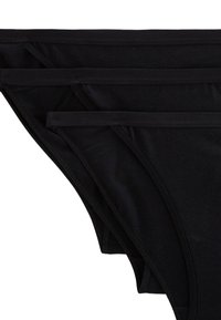 Ensemble de bikini noir en coton comprenant une texture lisse, une taille élastique fine et un design minimaliste.