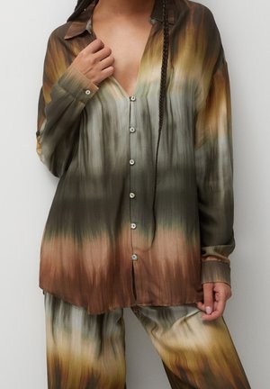 Chemise boutonnée à manches longues, présentant un motif dégradé en vert, marron et beige. Texture lisse, col et boutons à l'avant.