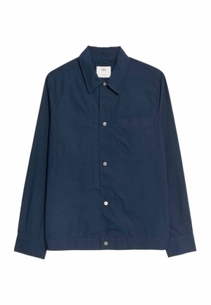 Veste décontractée bleu marine à manches longues avec des boutons-pression argentés, un col et une poche poitrine sur le côté gauche.