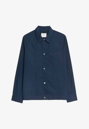 Camicia blu navy, con bottoni, colletto a punta, maniche lunghe e due tasche frontali. Realizzata in tessuto liscio con una leggera lucentezza.