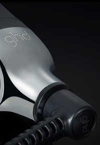 Fohn met een slank chroom lichaam, zwarte rubberen accenten en een gestructureerd snoer. Bevat het 'ghd' logo versierd met kleine steentjes.