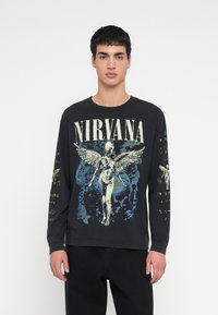 Czarna koszulka z długim rękawem z grafiką zespołu Nirvana. Projekt zawiera anielską postać, kolorowe akcenty oraz tekst na rękawach.